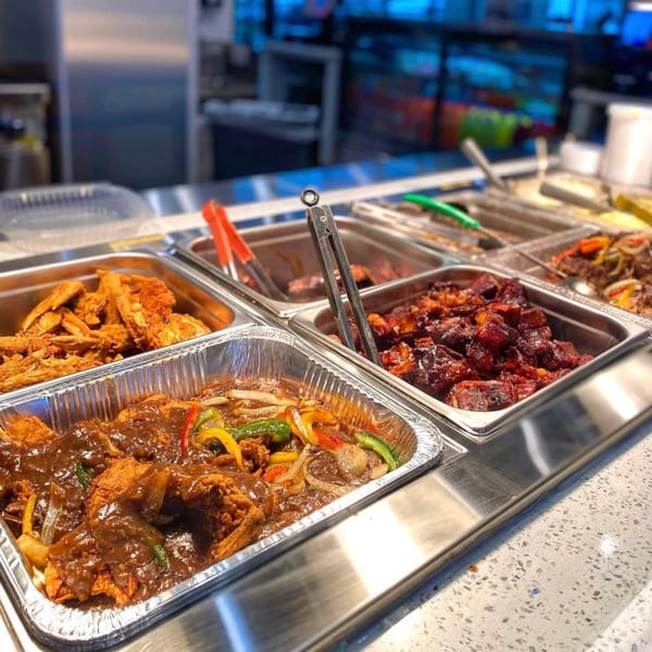 A buffet line at Ms. Ruby's Peach Cobbler Café with fried chicken, ribs, and smothered chicken.