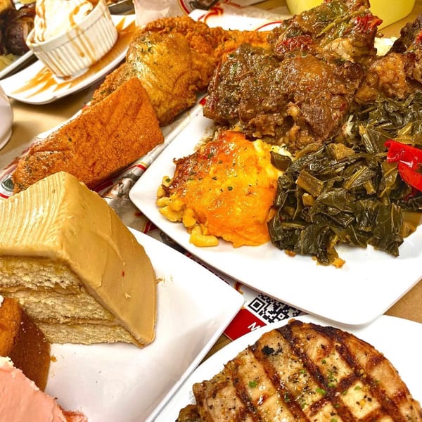 A soul food feast with fried fish, mac and cheese, collard greens, and cake.